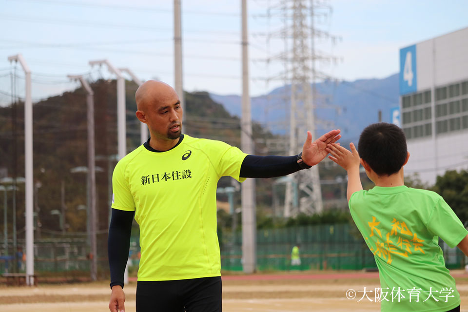 参加者とハイタッチする山本篤選手