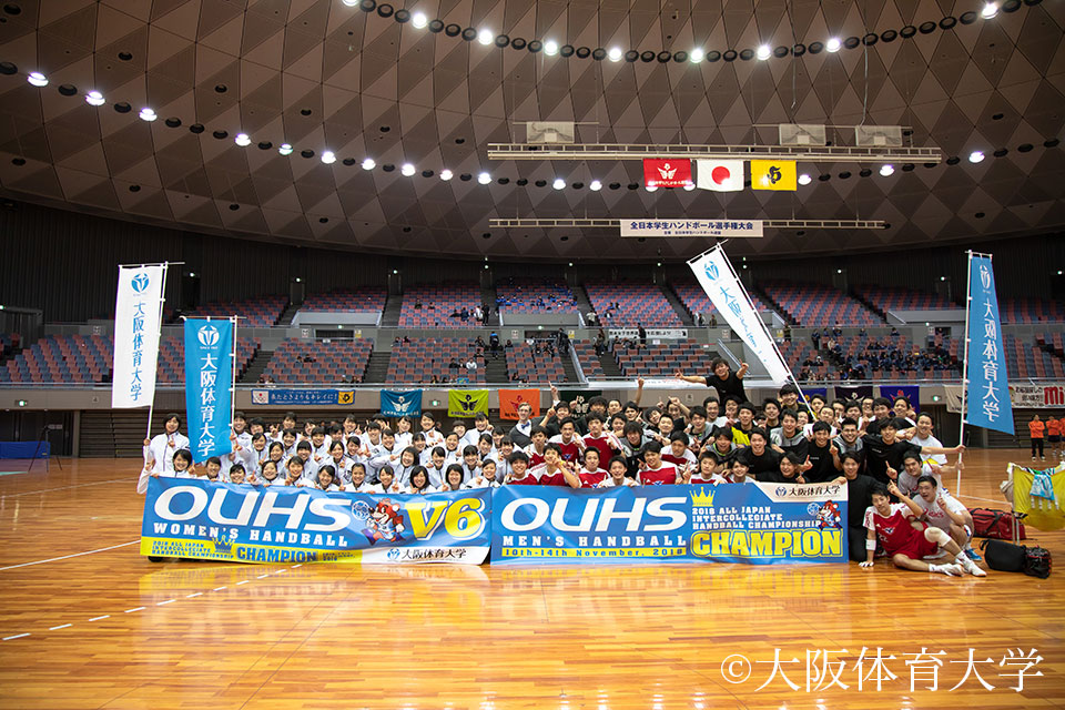 悲願の男女アベック優勝を果たし、勝利の横断幕で記念写真