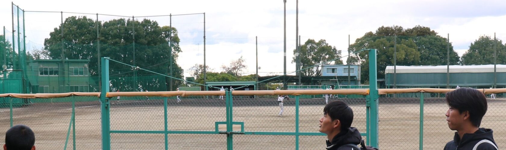 内野に甲子園球場の土と同じ産地の土を使用した野球場を案内する前瑛満さん、中井楓人さん