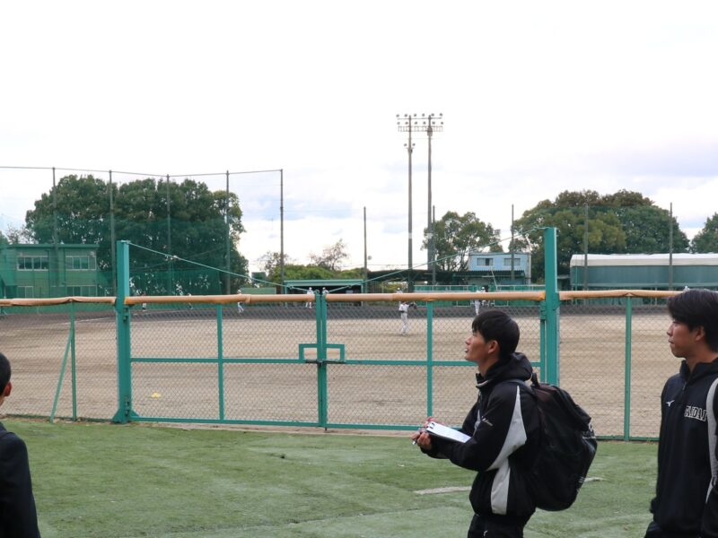 内野に甲子園球場の土と同じ産地の土を使用した野球場を案内する前瑛満さん、中井楓人さん