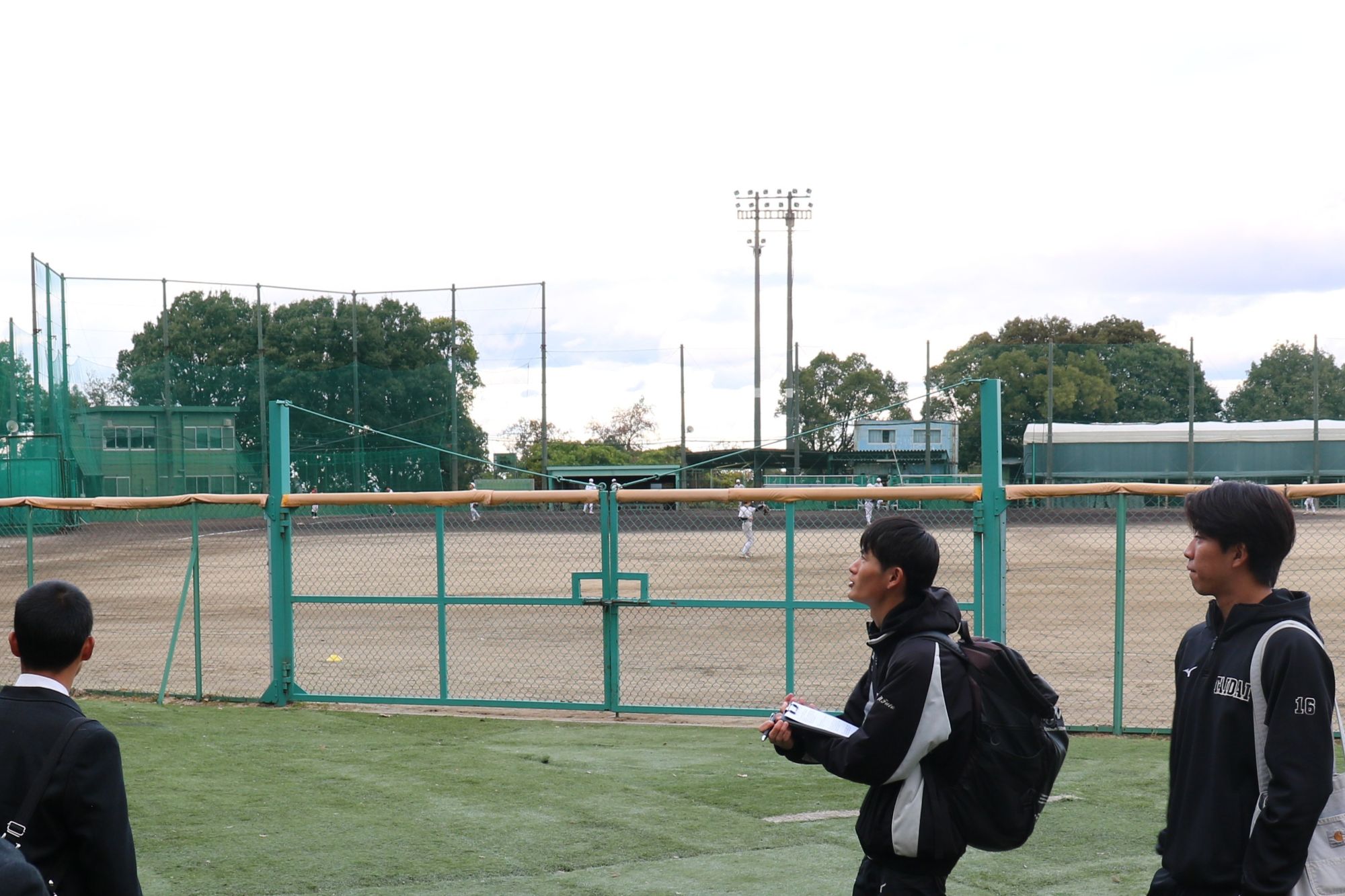 内野に甲子園球場の土と同じ産地の土を使用した野球場を案内する前瑛満さん、中井楓人さん