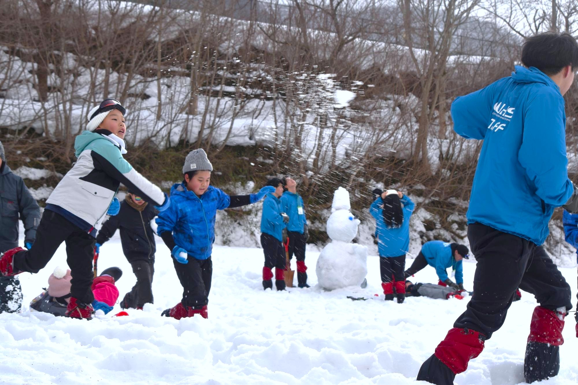みんなで雪合戦、後方には完成した雪だるま