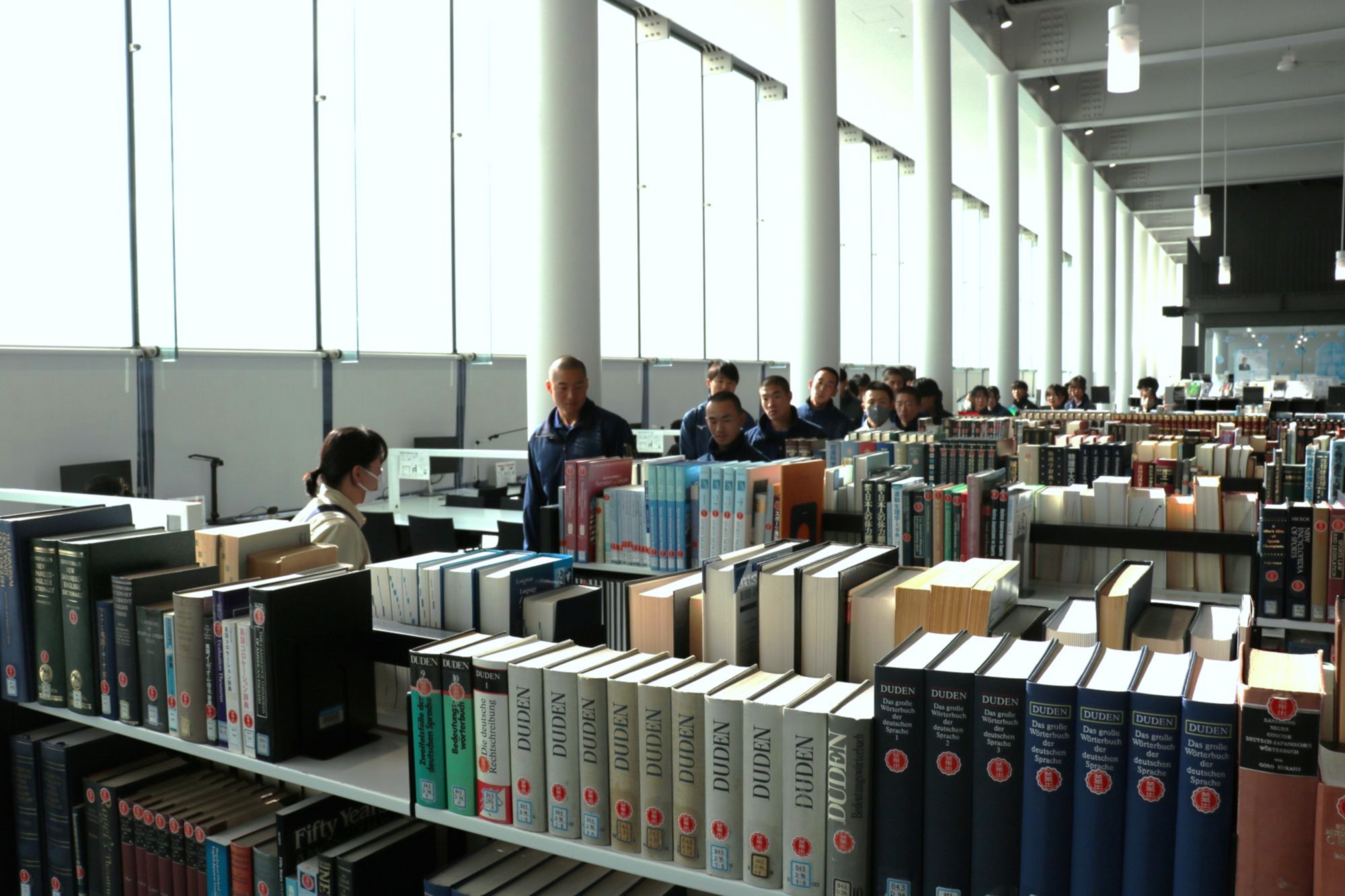 明るく開放感がある図書館を見学する生徒たち