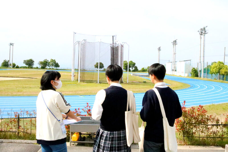 陸上競技場を見学する高校生