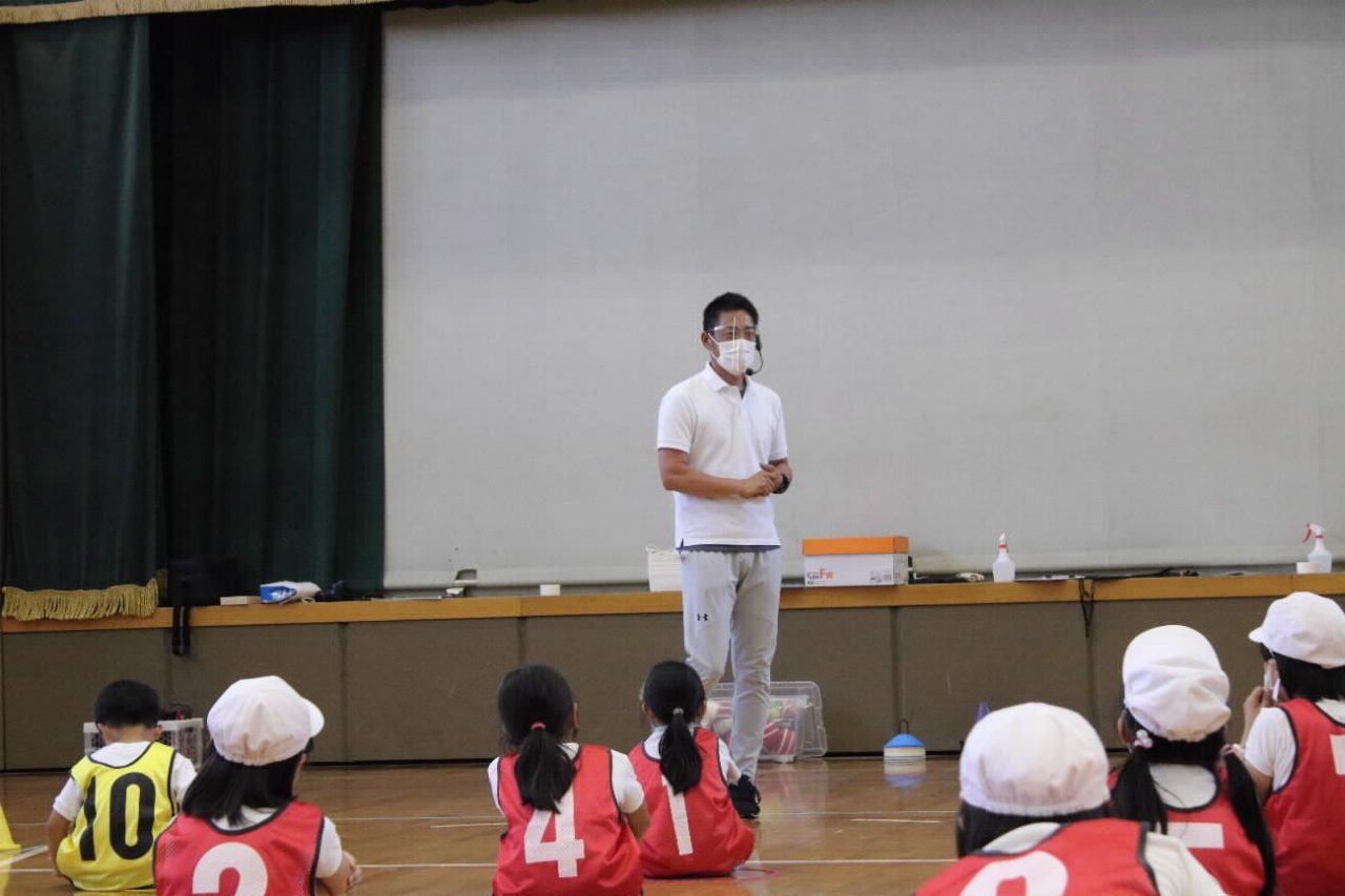 横井光治・硬式野球部女子監督の話を真剣に聞いている児童