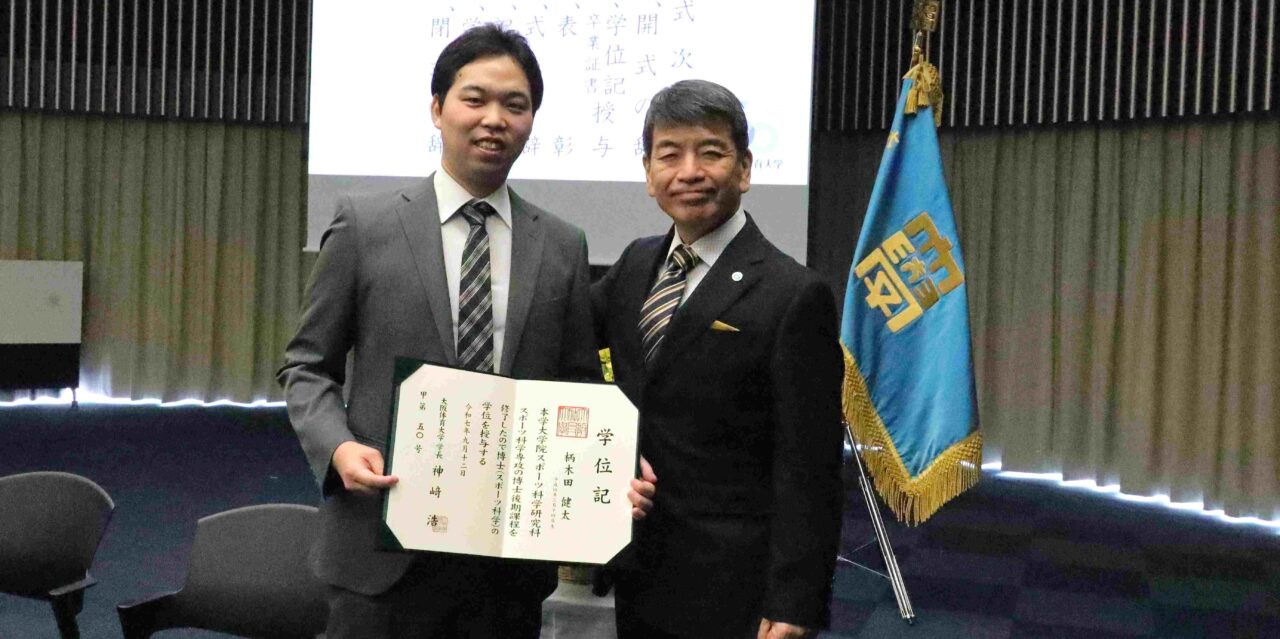 大阪体育大学大学院スポーツ科学研究科博士後期課程を修了した柄木田（からきだ）健太さん（左）と、指導教員の土屋裕睦教授（スポーツ心理学）