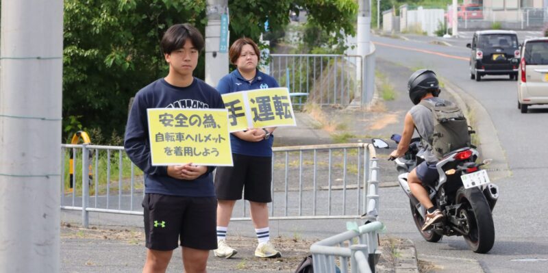 大学周辺の沿道で交通安全を呼びかけるクラブ生 【大阪体育大学】