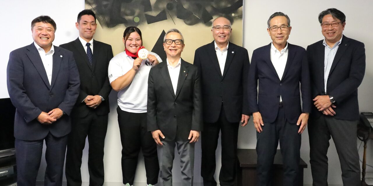 メダルを掲げる坂さん。その右から野田理事長、神﨑学長。その左から中西監督、植木コーチ
【大阪体育大学】