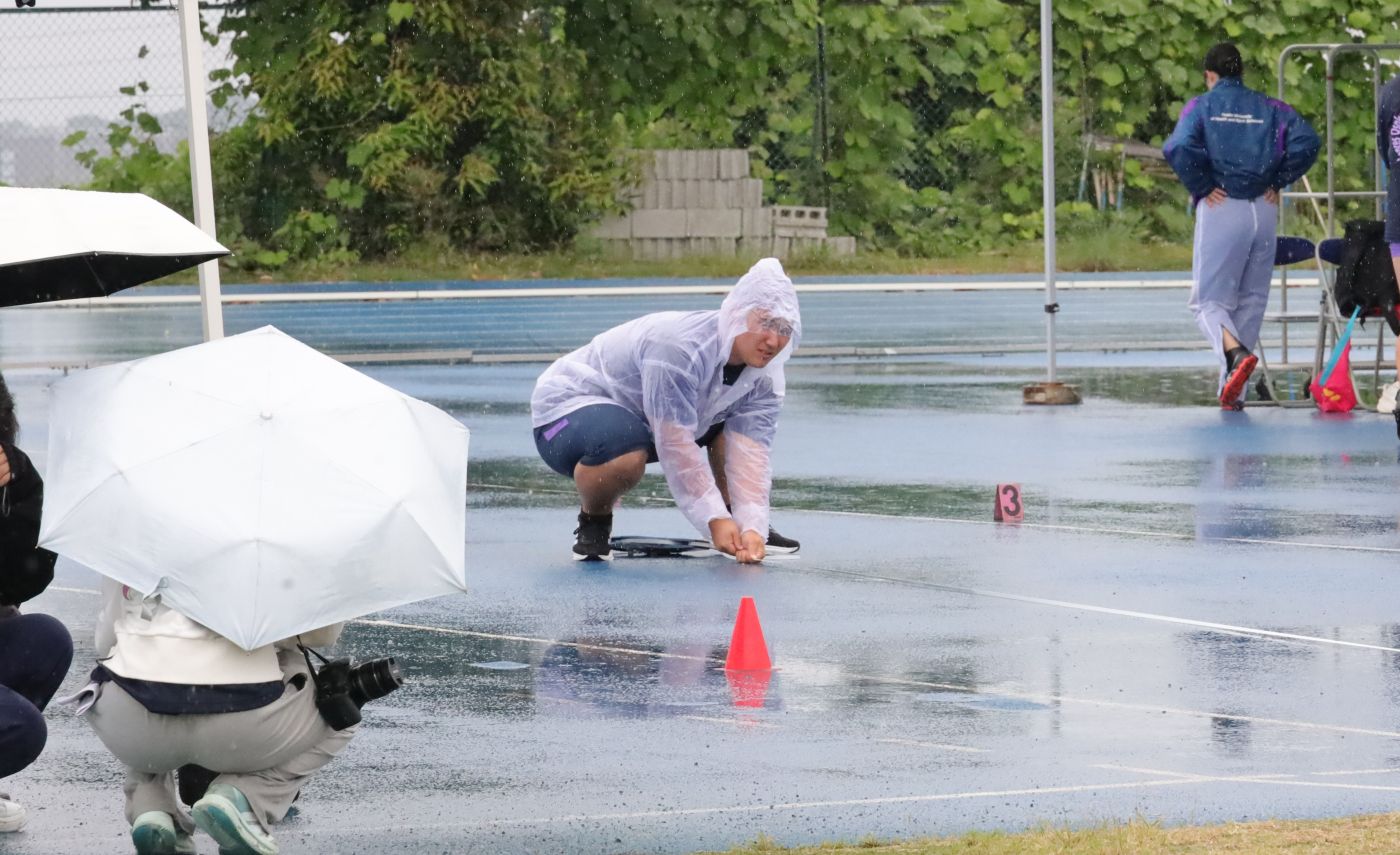 強い雨の中で陸上競技部投てきブロックの学生が記録を計測 【大阪体育大学】