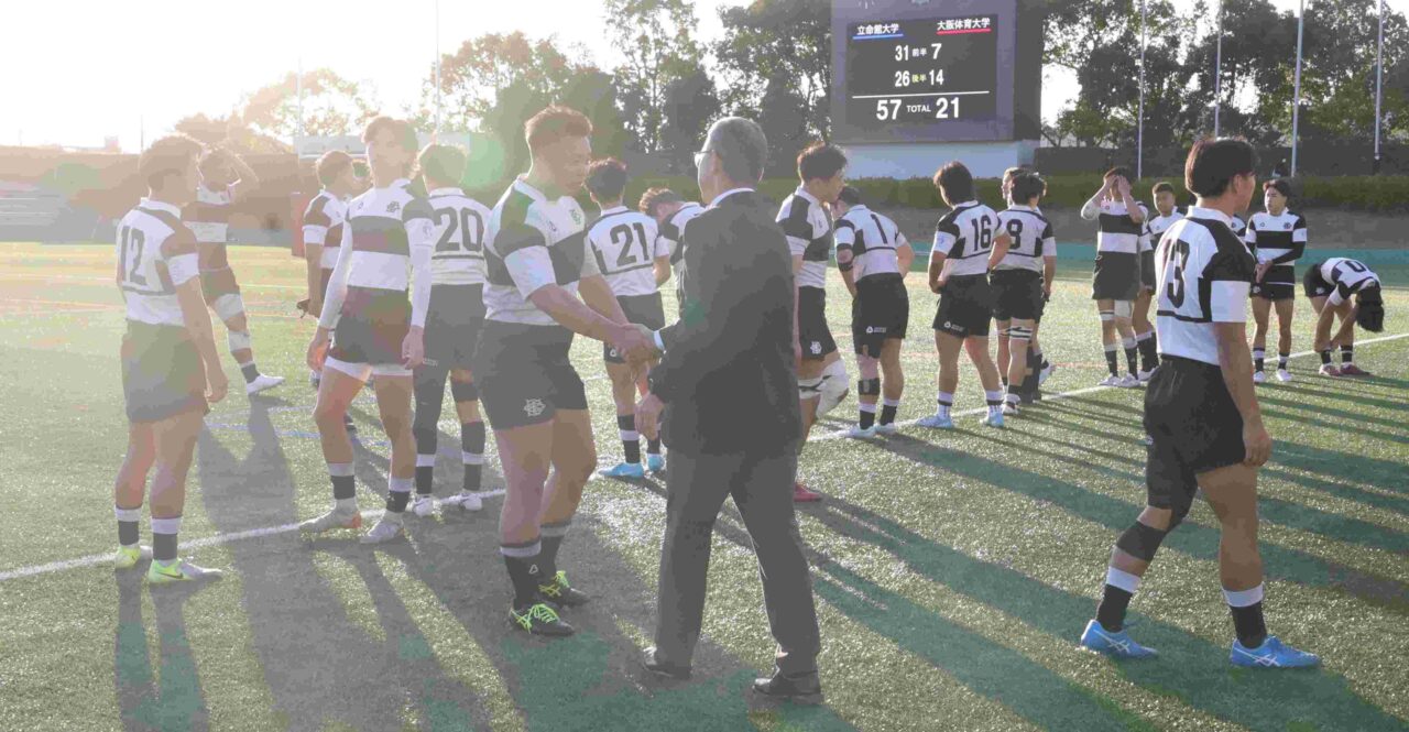 試合後、長崎正巳監督と握手する羽田賢信主将（体育学部４年、京都工学院高校）
【大阪体育大学】