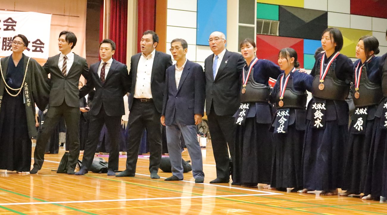 体大名物を歌う神﨑浩学長(剣道部顧問)、工藤俊郎部長、村上雷多監督 【大阪体育大学】