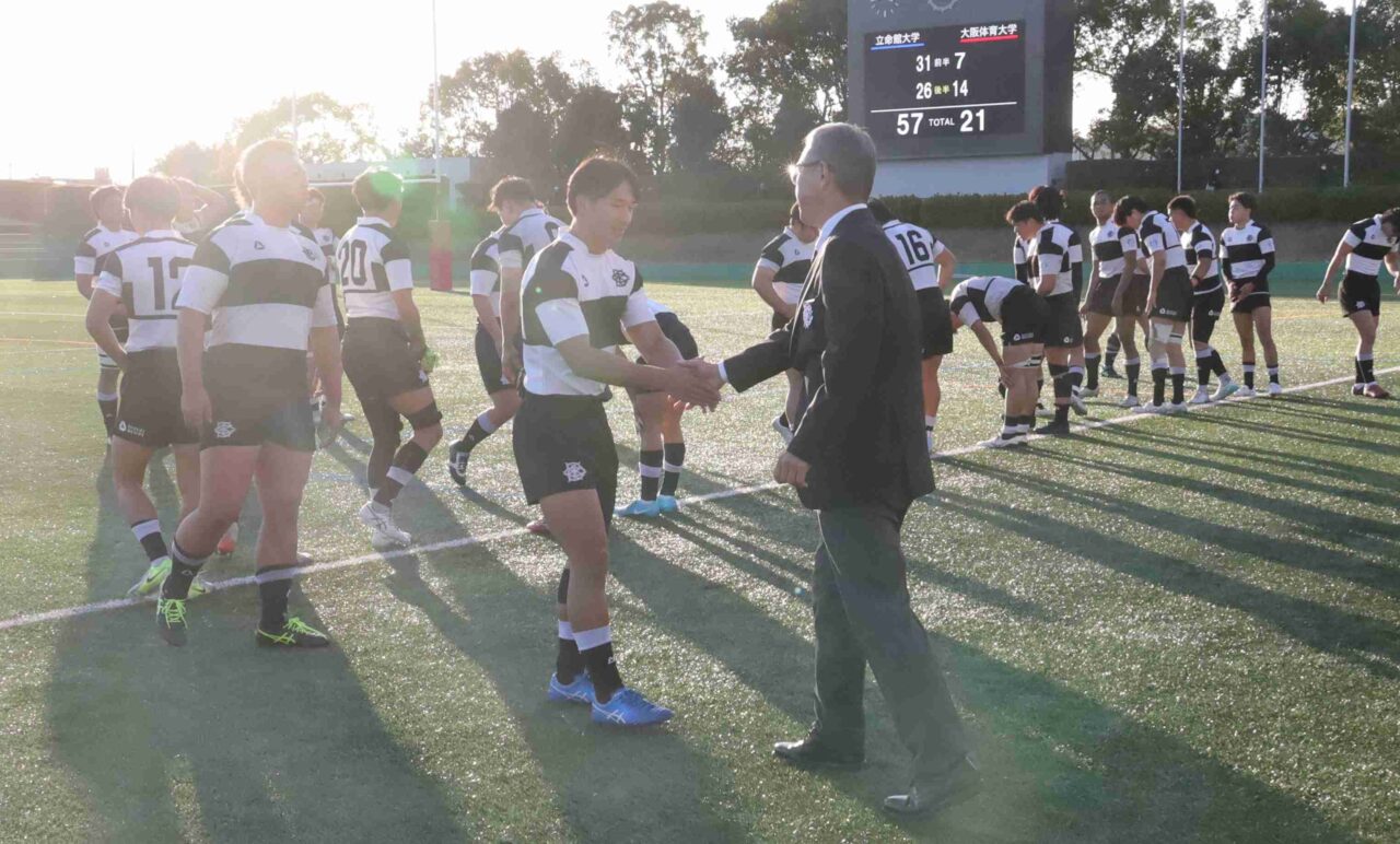 試合後、長崎正巳監督と握手する羽田賢信主将 【大阪体育大学】