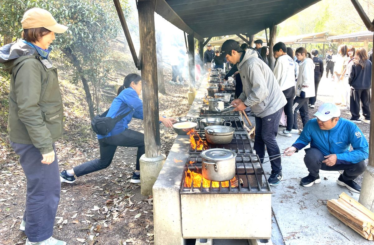 ２日目の昼食は野外炊事でカレー作り。班の８人が役割分担する 【大阪体育大学】