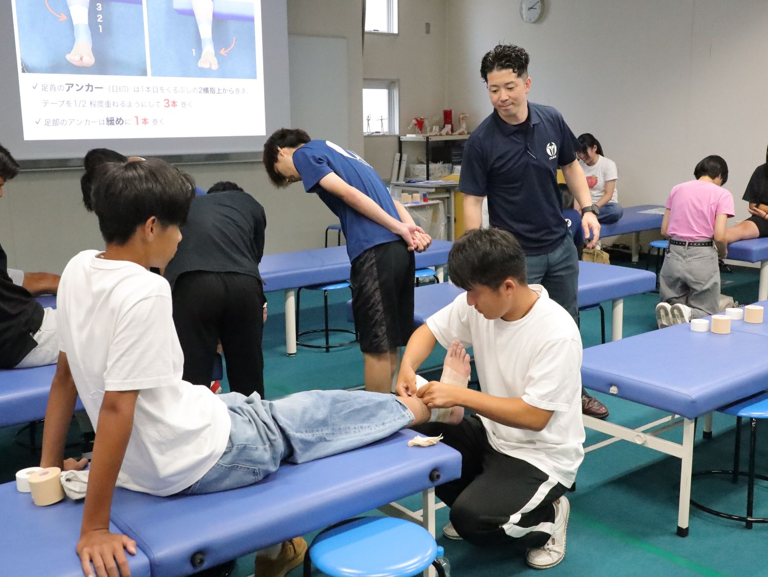 テーピング実技体験会 本学はアスレティックトレーナー(AT)資格と教員免許が両方取れる数少ない大学で、AT志望の入学生が多い