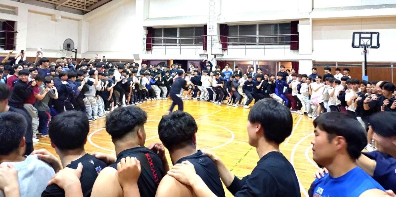 ヒューマンチェア。前の人の肩を持ち後ろの人のひざに座る。数人から始めて、大きな輪に 【大阪体育大学】