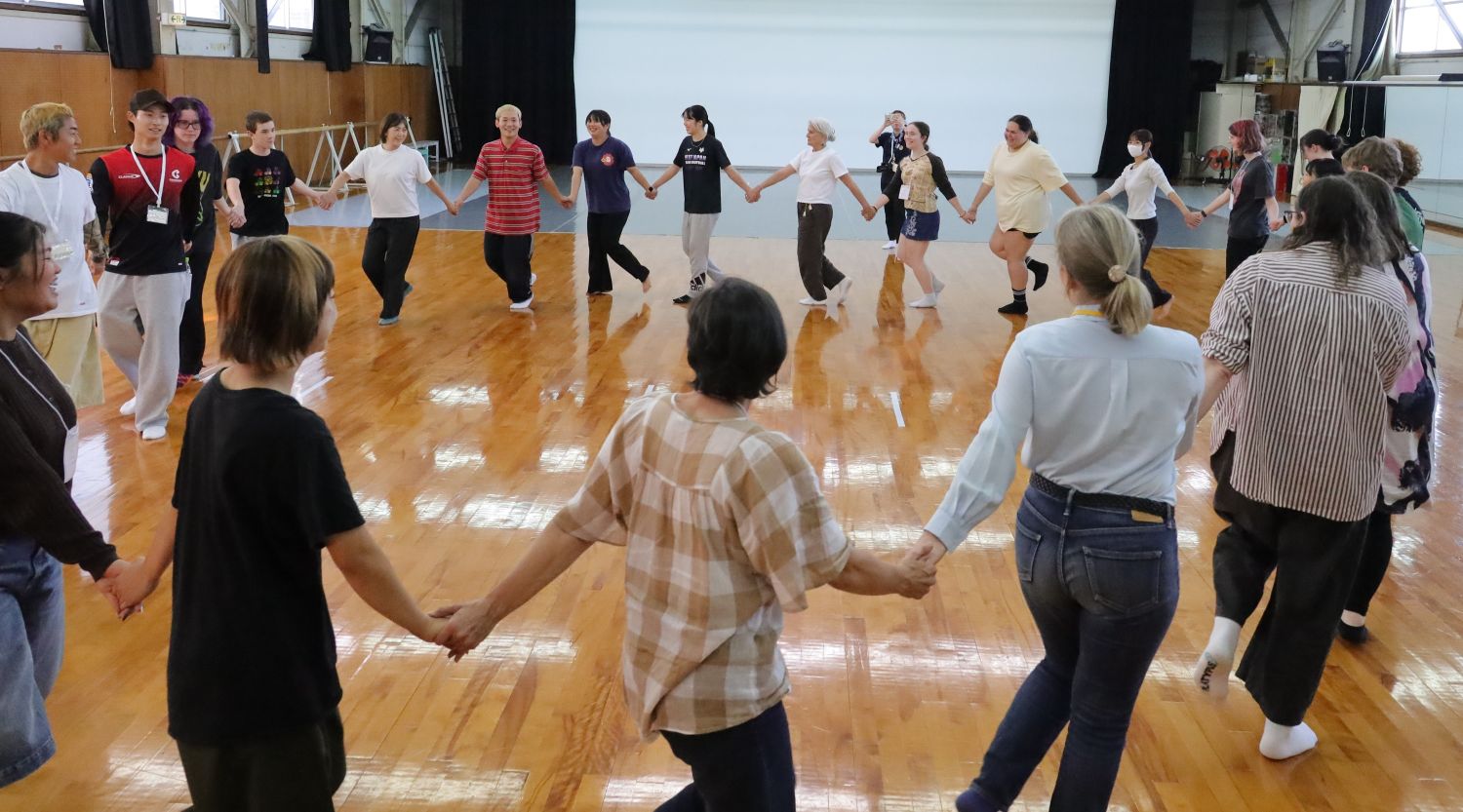 ダンス部員と手をつなぎ輪になって踊る参加者。盆踊りも 【大阪体育大学】