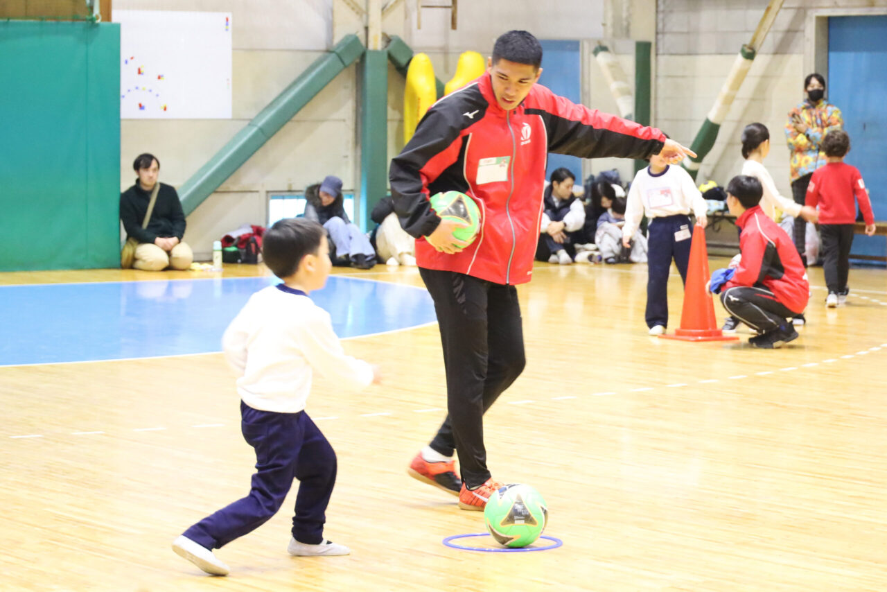 OUHSスポーツキャンプで子どもにサッカーを教えるサッカー部男子部員
【大阪体育大学】