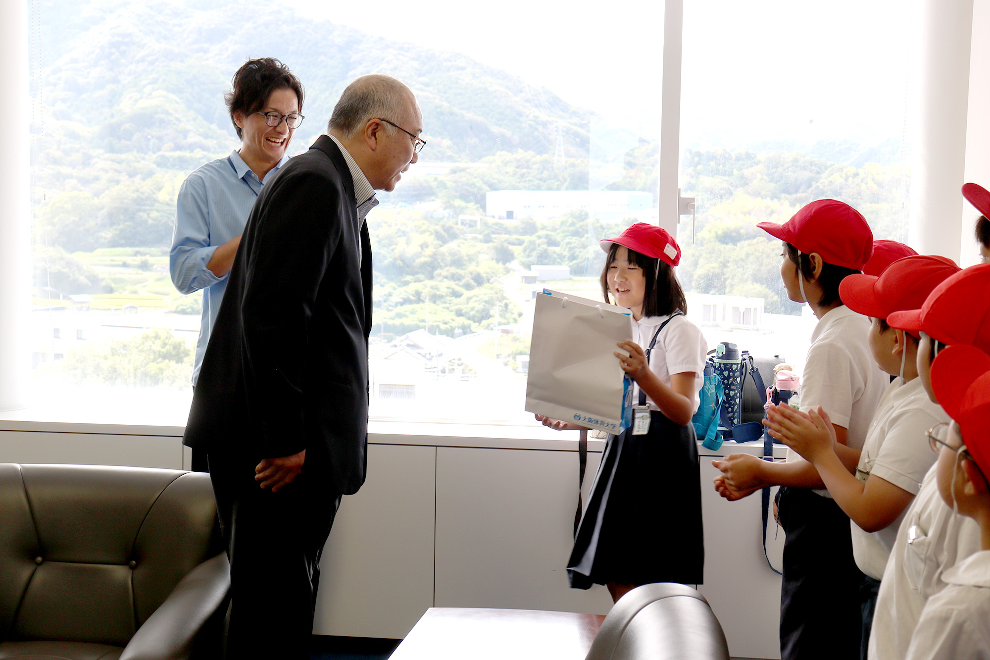 神﨑浩学長から児童にオリジナルグッズをプレゼント