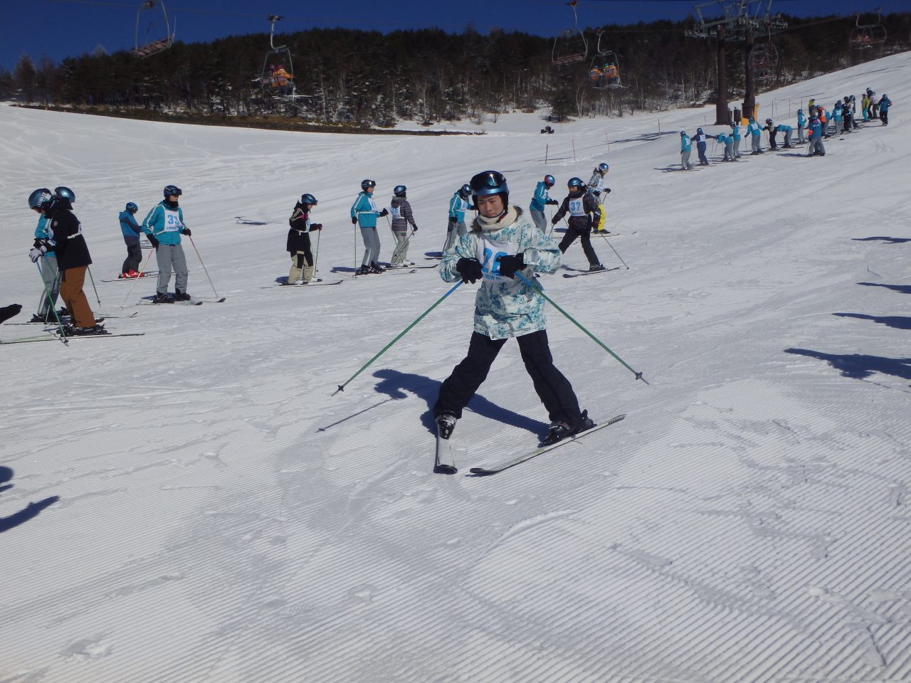 教員からスキーの講習を受ける学生